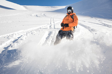 Freeride snowboarder sliding down the mountain slope