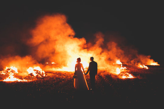 Amazing wedding couple near the fire at night