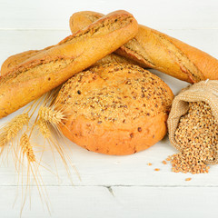 Fresh bread and wheat on the wooden table.