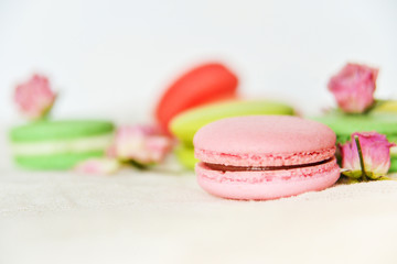 Dessert: A Delicate Fresh Colorful French Macaroons In Pastel Colors Gift Box Flowers Roses On Light Textiles Background
