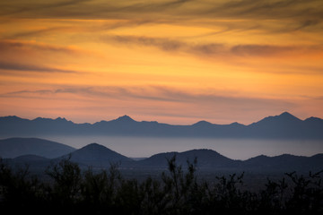 Colorful sunset with layers of mountains and mist