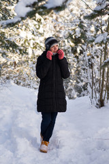 girl in red gloves. In the forest tree snow on the branches.