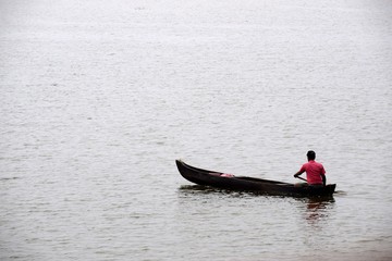 Fisher men rowing canoe