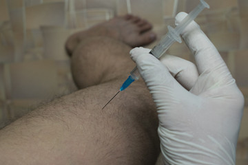 injection of a syringe into the muscle of the thigh - obrazy, fototapety, plakaty