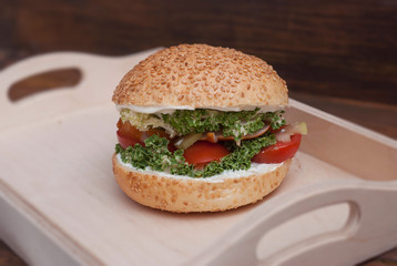 Homemade Burger in Wooden box, with fresh Vegetables on rustic Wooden Background with copy Space. Rustic Fast food.