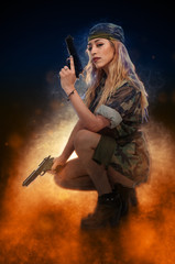 Obraz premium Gun toting beautiful young woman soldier with pistols