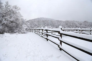 Snowy corral fence wintertime as a background panoramic photo