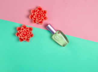 Flat lay minimalism of a perfume  bottle and candles in the form of flowers on a pastel background..