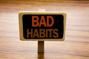 Conceptual hand writing text caption inspiration showing Bad Habits. Business concept for Improvement Break Habitual Hebit written on announcement board on the wooden wood background.