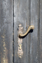 Obraz premium Old door handle on wooden closed door