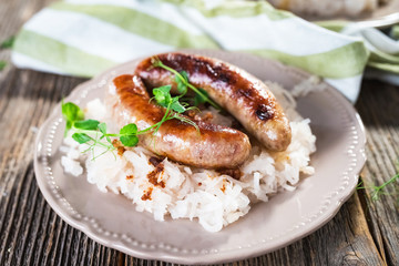 Plate of sausages and sauerkraut on wooden table