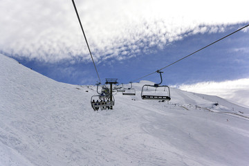 Fototapeta na wymiar Snowy landscape of Sierra Nevada with blue sky, chairlift and white mountains with snow..