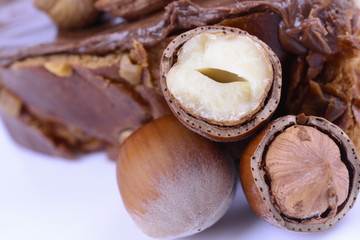 hazelnuts and bun with chocolate cream on white background