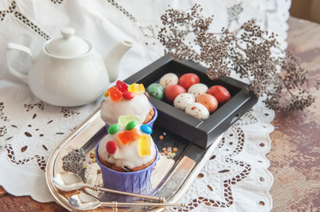 Easter cakes with icing and marmalade decoration and caramel marzipan eggs in a box. Easter decor. Close up.