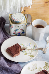 Millet brownie. White plates, cups of coffee and black esspreso maker. White and light blue background. Woolen tapestry.
