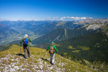 Fototapeta premium Two hikers with backpacks in the mountains of Montenegro. View from Trojan peak