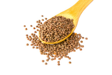 Brown lentils in a wooden spoon. Lentils in a spoon of bamboo on a white background.
