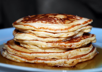 Closeup of Golden Fluffy Pancakes Doused in Maple Syrup