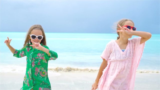 Little girls having fun at tropical beach playing together