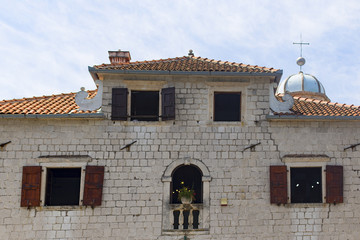 old house with a red roof and open Windows