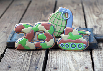 Homemade Gingerbreads in the form of a grenade, tank and the numbers "23" in protective khaki color on Defender of the Fatherland Day