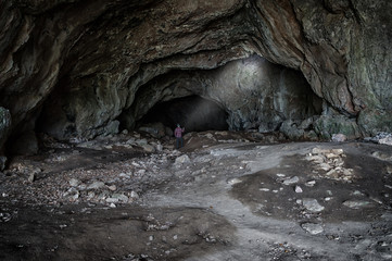 Mann forscht in dunkler, riesiger Höhle mit Taschenlampe