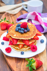 dish with pancakes and strawberry,raspberry and blueberry