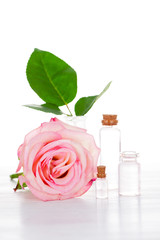 Pink rose and glass bottles with transparent liquid