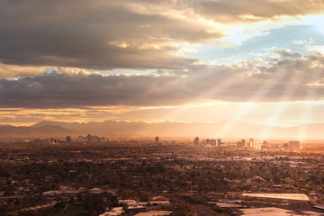 Fototapeta premium Phoenix,Az,USA; Aerial view of the downtown area, sun rays peaking through clouds.