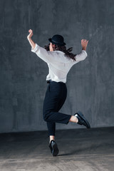 Young beautiful female dancer is posing in the studio