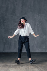 Young beautiful female dancer is posing in the studio