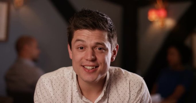 4K Happy young man making small talk while on a date in a bar. As seen from his date's point of view.