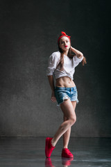Young beautiful female dancer is posing in the studio