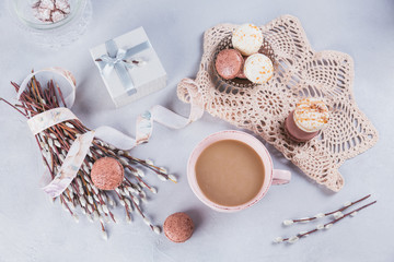 Pink coffee mug with sweet pastel french macaroons, gift box and pussy willow