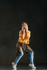 Young beautiful female dancer is posing in the studio