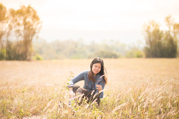 Naklejka na ściany i meble Asian woman sitting on the grass field outdoor travel