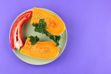 Halves of a pumpkin and red pepper on a green plate, pumpkin on a purple background, vegetables pop art, minimalism, orange and red vegetables on a purple background, Bulgarian pepper, pumpkin for a d