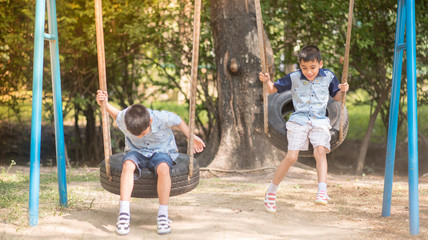 Little boy playing tire swing in the park playground