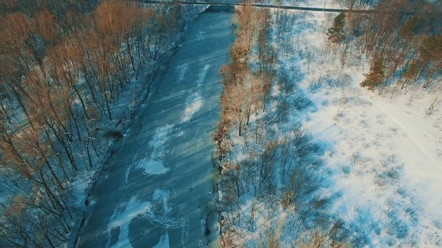 Aerial view on frozen lake at winter forest drone footage