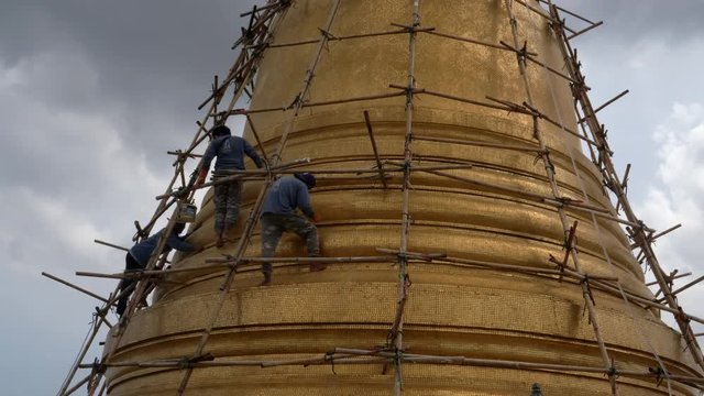 workers repair the chedi at phu khao thong, golden mount, at wat saket in bangkok, thailand