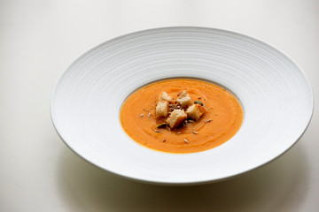 Pumpkin cream soup in white plate