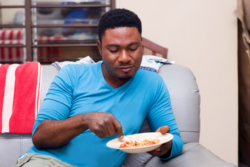 young man eating spaghetti