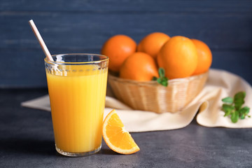 Glass of fresh orange juice with slice on table