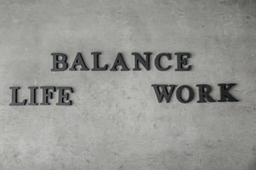 Word "BALANCE", "LIFE" and "WORK" made of wooden letters on gray background