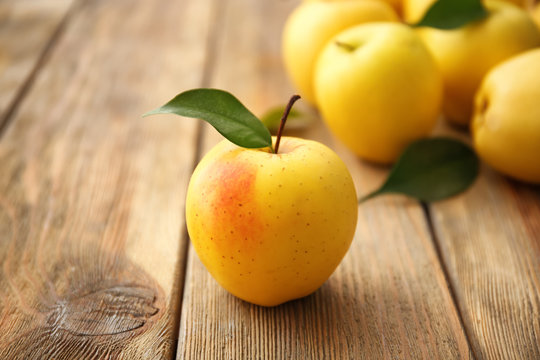 Ripe yellow apple on wooden table
