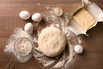 Raw dough and ingredients on kitchen table