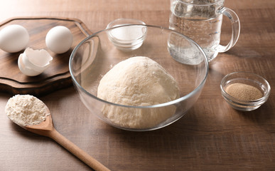 Raw dough and ingredients on kitchen table