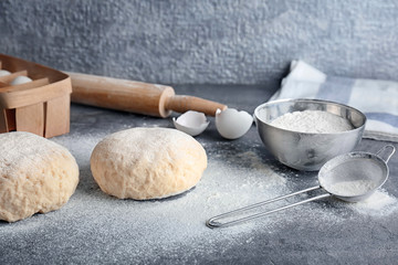 Raw dough with ingredients on kitchen table