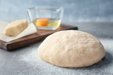 Raw dough with ingredients on kitchen table