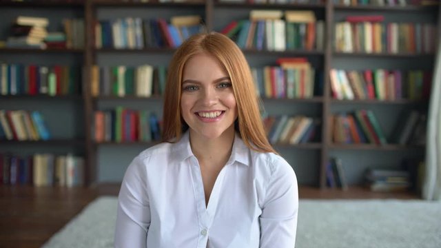 portrait of beautiful young woman with attractive smile. portrait of beautiful young smiling woman student with attractive smile in library. 4 k Woman smiling closeup portrait. Young business woman